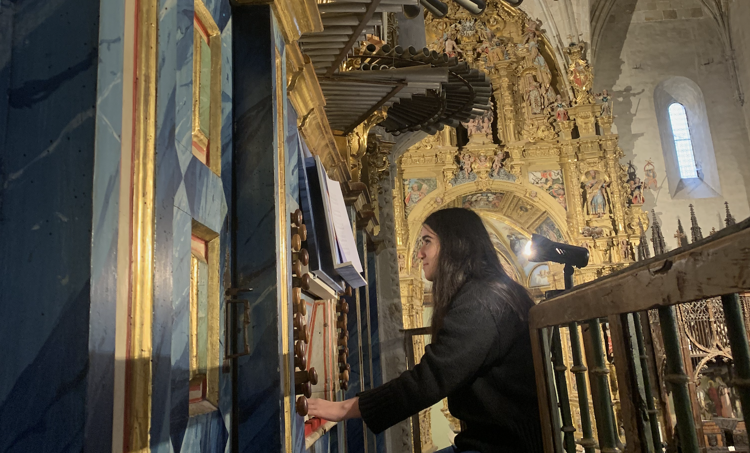 La estudiante María Soto, de la FCEE, coordinadora de la iniciativa estudiantil "Aula de Música Medieval", acompaña en el órgano barroco el canto medieval de los estudiantes.